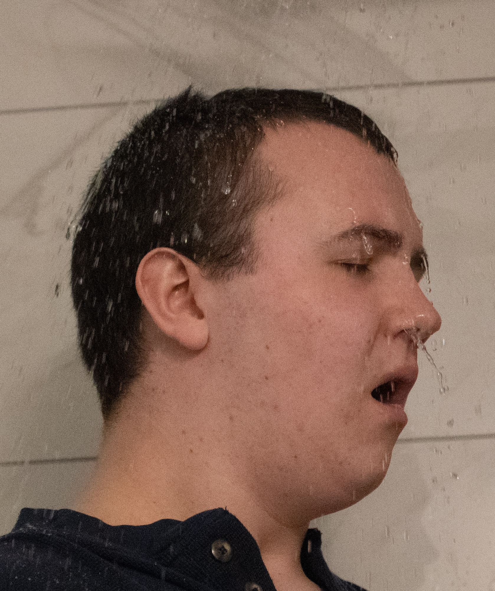 Kory letting the shower spray cold water on him