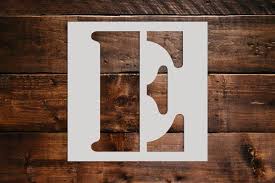 Stencil of the letter 'e' on a wooden backdrop.